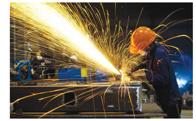 Image of worker operating industrial saw